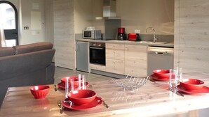 Une cuisine moderne avec un coin repas, équipée d’un four à micro-ondes, d’une machine à café, d’un grille-pain et d’un lave-vaisselle.