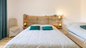 A bedroom with a bed, bedside tables, a chair, and a nightstand. - Modern house with bikes, near Sartilly trails (Sartilly)
