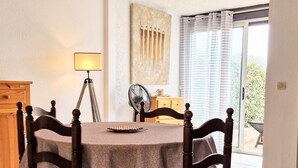 Un coin repas avec une table ronde, quatre chaises, une lampe et un tableau au mur.