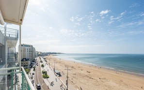 Une plage offrant une vue dégagée sur la mer et sur les bâtiments qui se dressent à l’arrière-plan.