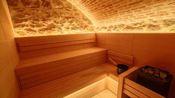 A sauna with wooden benches and a stone wall.