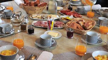 Et morgenbord med forskellige spiser, drikkevarer og bestik.