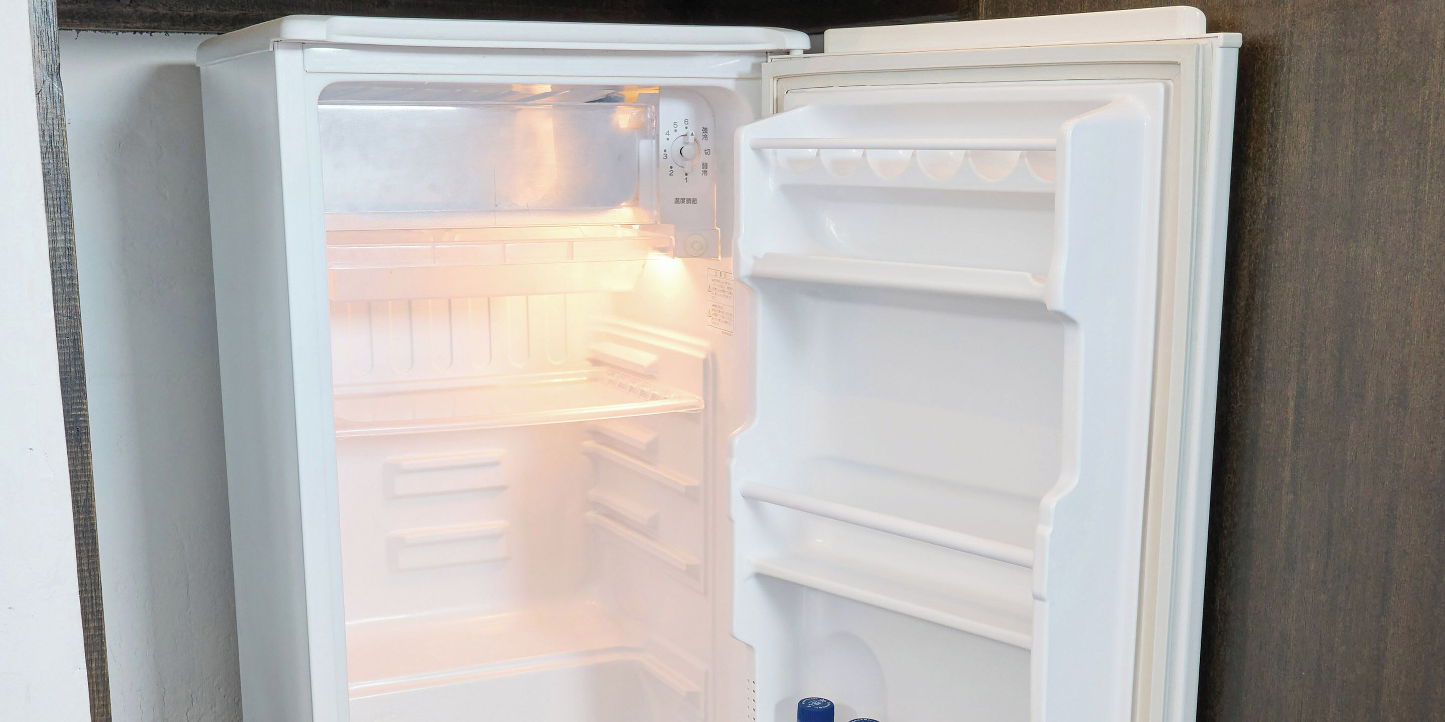An open refrigerator with multiple shelves and a water dispenser.