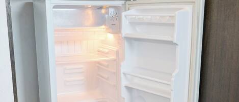 An open refrigerator with multiple shelves and a water dispenser.