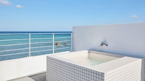 Ein Pool auf dem Dach mit freiem Blick auf den Ozean.