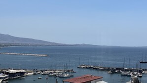 A marina with boats docked, a pier extending into the water, and a mountainous backdrop. - Piraeus House With Sea View and Free Parking (Piraeus)
