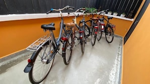 Varias bicicletas están estacionadas contra una pared en un espacio exterior estrecho.