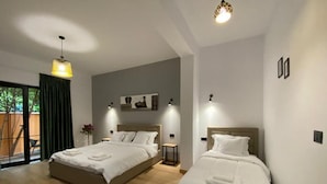 Una habitación de hotel moderna con dos camas, un ventanal con vistas y una lámpara en el techo.