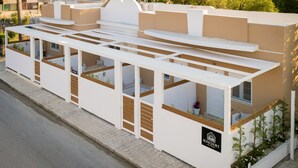 Un bâtiment moderne doté de nombreux balcons, une enseigne indiquant « SUNCOURT », et un trottoir dallé.