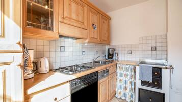 A kitchen with wooden cabinets, a gas stove, a dishwasher, and a built-in oven.