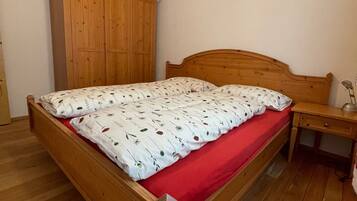 Una camera da letto con un letto e un armadio in legno, una scrivania e una lampada a sospensione.