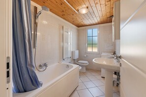 Un bagno con vasca, water e lavandino.