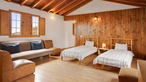 A room with a wooden ceiling, a sofa, two beds, and a nightstand. - Vacation Home 'Mirador de la Abuela' with Sea View, 2 Terraces & Wi-Fi (Gáldar)