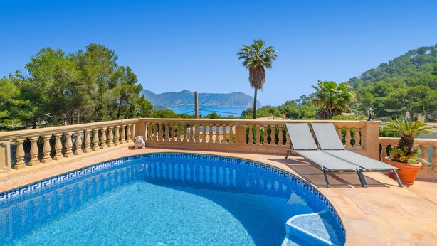 A swimming pool with a curved edge, surrounded by a balustrade, and overlooking a scenic landscape with trees and mountains. - Villa Casa Soleada with Sea View, Pool, Terraces & Wi-Fi (Capdepera)