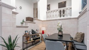 A modern interior with a dining table, chairs, a sofa, a small staircase, and a balcony. - Villa Casa Soleada with Sea View, Pool, Terraces & Wi-Fi (Capdepera)