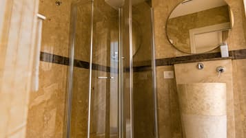 Ein Badezimmer mit Duschkabine, Waschbecken und Spiegel.