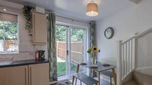 A kitchen with a dining area, a clock, and a view of the outdoors.