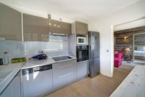 Une cuisine compacte dotée d’appareils électroménagers modernes, d’un lave-vaisselle et d’un four à micro-ondes.