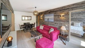 Un salon moderne avec un canapé rouge, une table à manger et un grand miroir.