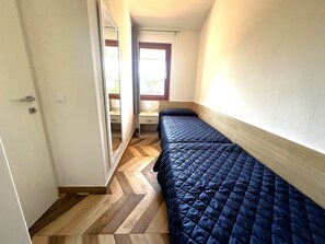 Cozy retreat with a single bed, bedside table, and window for natural light.