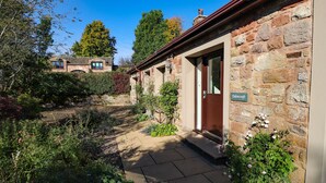 A stone building with a wooden door and a sign reading "Edencroft." - Edencroft (Penrith)