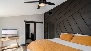 A modern bedroom with a bed, a desk with a TV, and a ceiling fan. - 2Kings 2Doubles - Boat Dock in Cozy Cove PetsAsk (Mead)