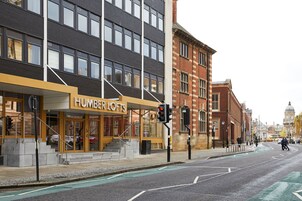 A building with a sign reading "HUMBER LOFTS" and a staircase leading to the entrance.