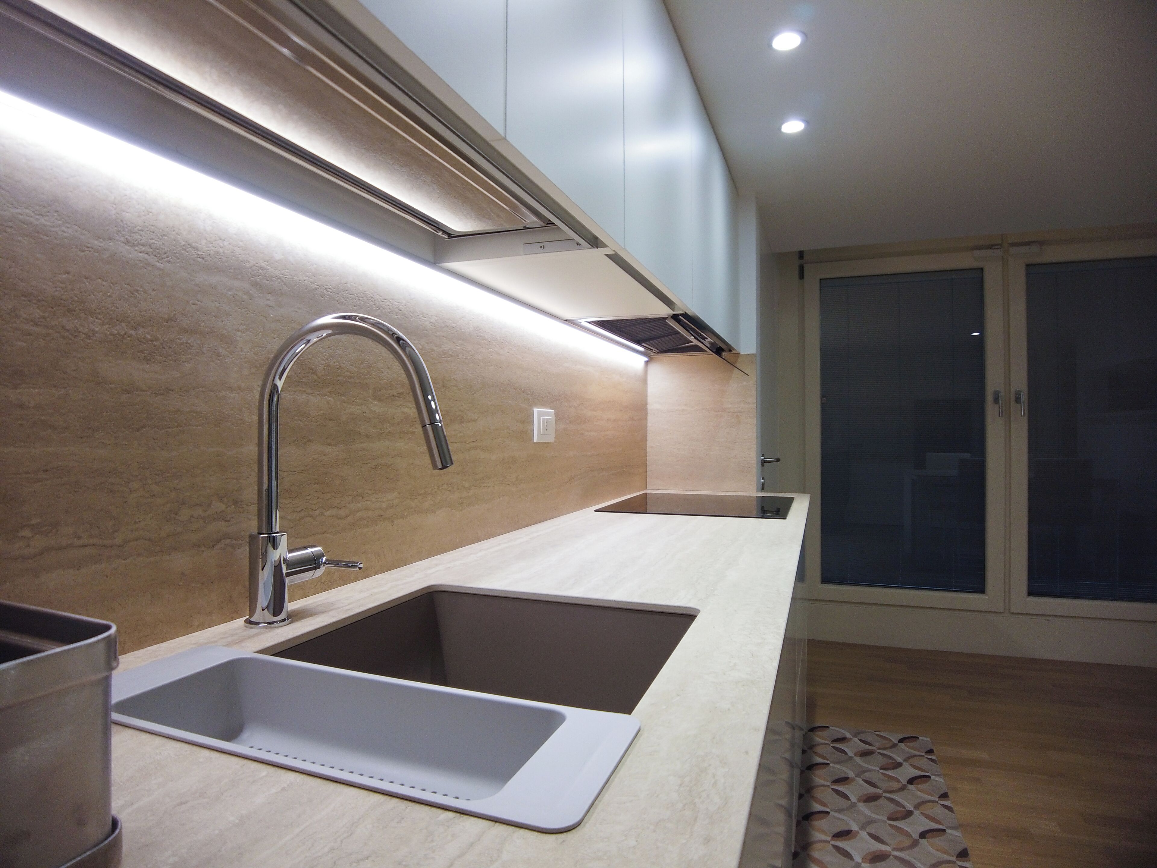 A modern kitchen with two sinks, a stainless steel faucet, and a built-in oven.