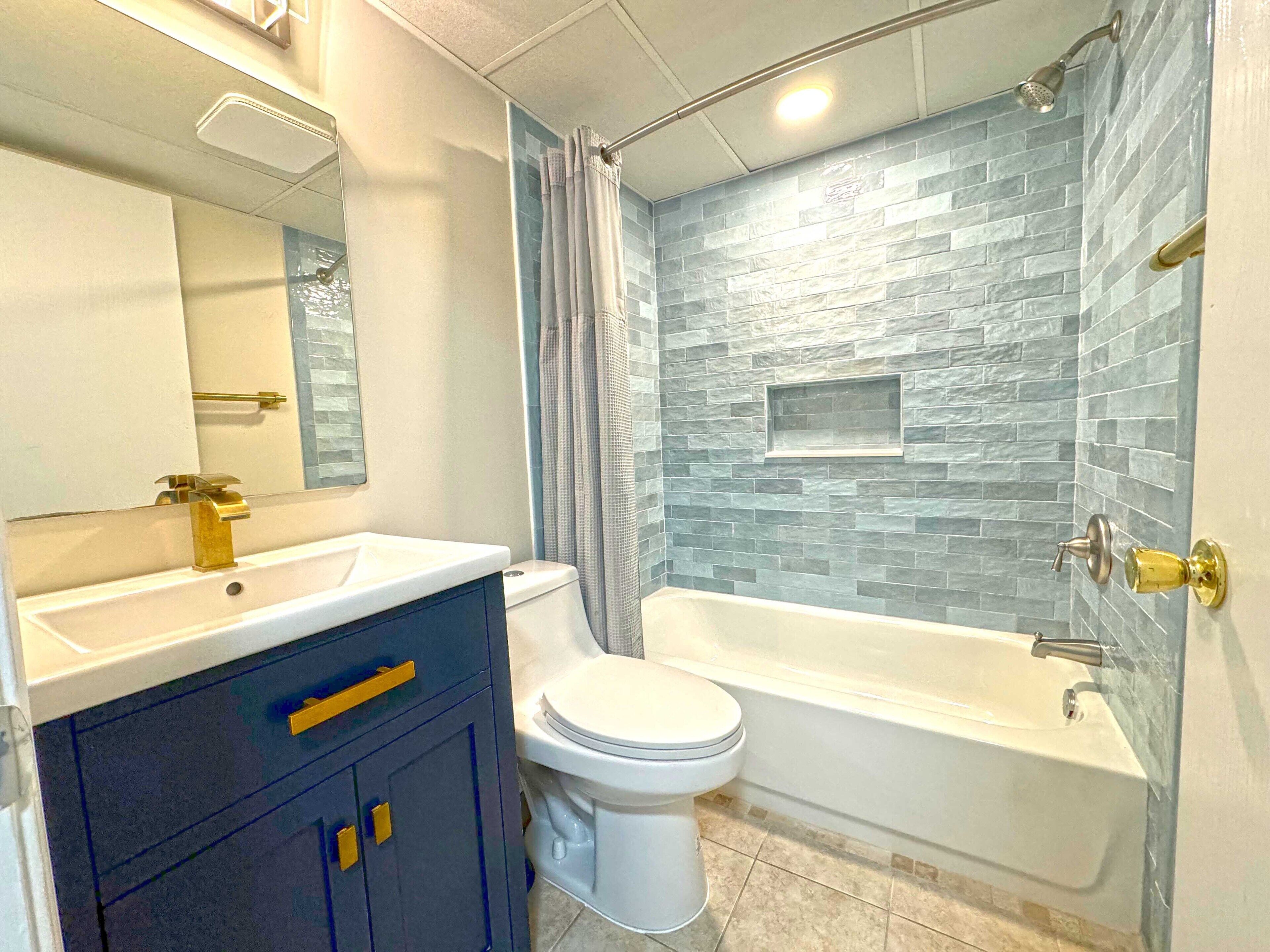 Une salle de bain avec un lavabo blanc, des toilettes et une baignoire.