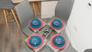 A dining table with four chairs, each with a blue and red plate. - TMS Beautiful 2BR Apartment! Ensuite! Lakeside (Grays)