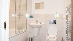 A bathroom with a glass-enclosed shower, a pedestal sink, and a toilet. - TMS Beautiful 2BR Apartment! Ensuite! Lakeside (Grays)