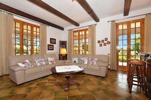 A living room with a sofa, a round table, a lamp, and a wooden stool. - Villa Cerbaie (Fucecchio)