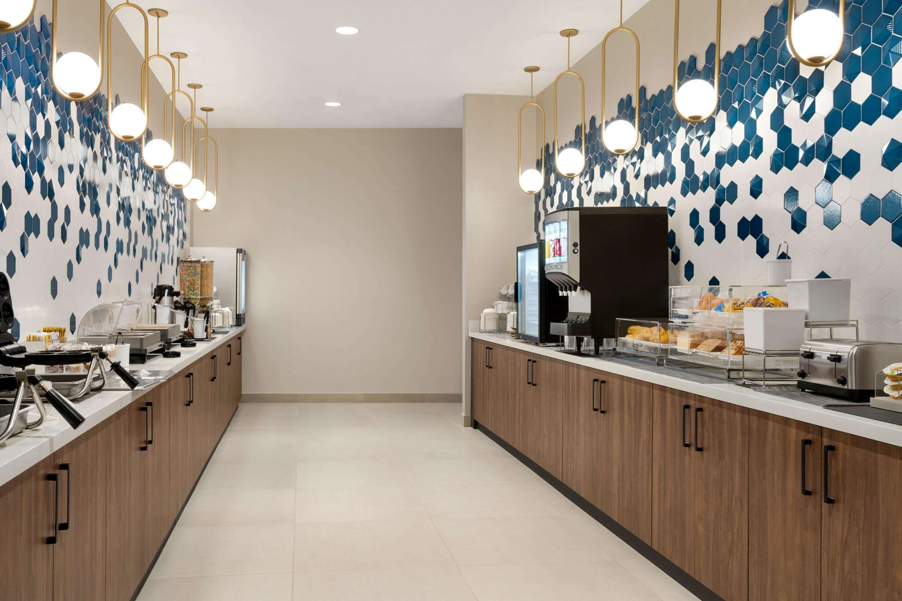 Una cocina moderna con una encimera amplia, equipada con cafetera, tostadora y diversos alimentos.