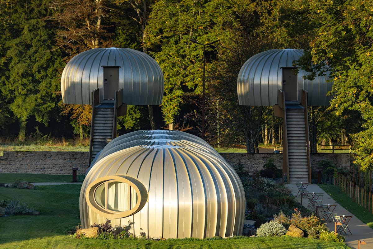 A spherical building with a circular window and a staircase leading to a door.