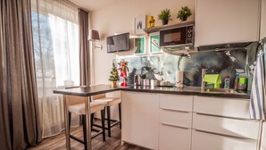 Una cocina moderna con barra, armarios blancos y un amplio ventanal con cortinas.