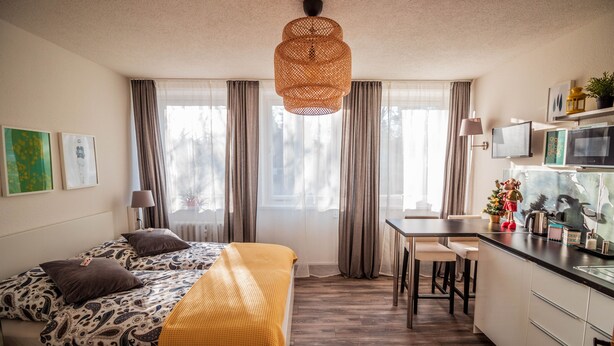 Una habitación de hotel moderna con cama, escritorio y kitchenette.