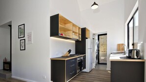 A modern kitchen with a central island, built-in appliances, and a wooden cabinet above the stove.