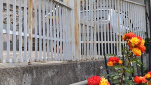 A white metal fence with a rusted post marked with the number 58, leading to a building with a tiled roof and potted plants on the balcony. - Adriana House ground floor with enchanting lake view (Bee)