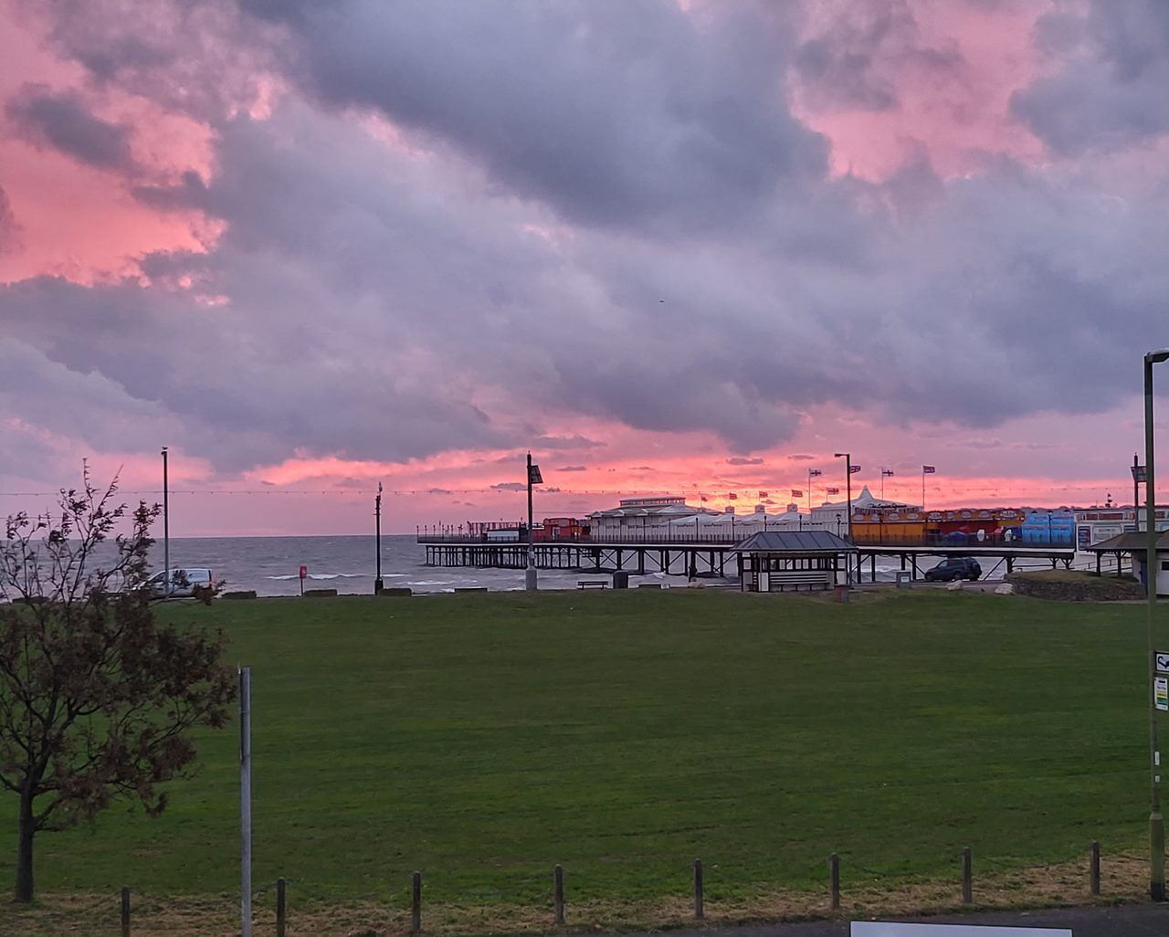 A pier extending into the water with a sunset in the background.