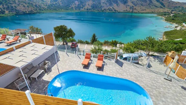 A pool area with lounge chairs and a view of a lake and mountains. - Gorgeous Lake Kournas Villa Brand New Private Pool (Apokoronas)