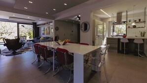 A modern kitchen with a central island, bar stools, and a dining area. - Alcantara Home view (Gravà - Castiglione di Sicilia)