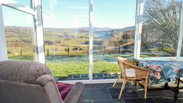 A conservatory with a view of rolling hills and a grassy field. - Ty Twmp / Tump Cottage (Brecon)