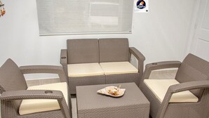Un conjunto de sofá de mimbre con cojines, una mesita y un plato decorativo.