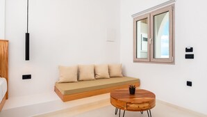 A modern, minimalist room with a wooden bench, a round wooden table, and a window with a view.