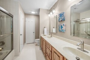 Ein modernes Badezimmer mit bodengleicher Dusche, einem geräumigen Waschtisch mit Becken und einer Toilette.