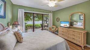 A bedroom with a bed, a television, a ceiling fan, and a view of the outdoors. - 3BD Villa Sandestin Resort, Golf Cart Included (Destin)