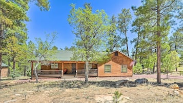 Enjoy the serene forest surroundings from the porch of this single-story lodge.