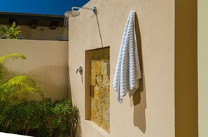 Une salle de bain avec une douche, une serviette accrochée au mur et une porte dotée d’un trou de serrure.