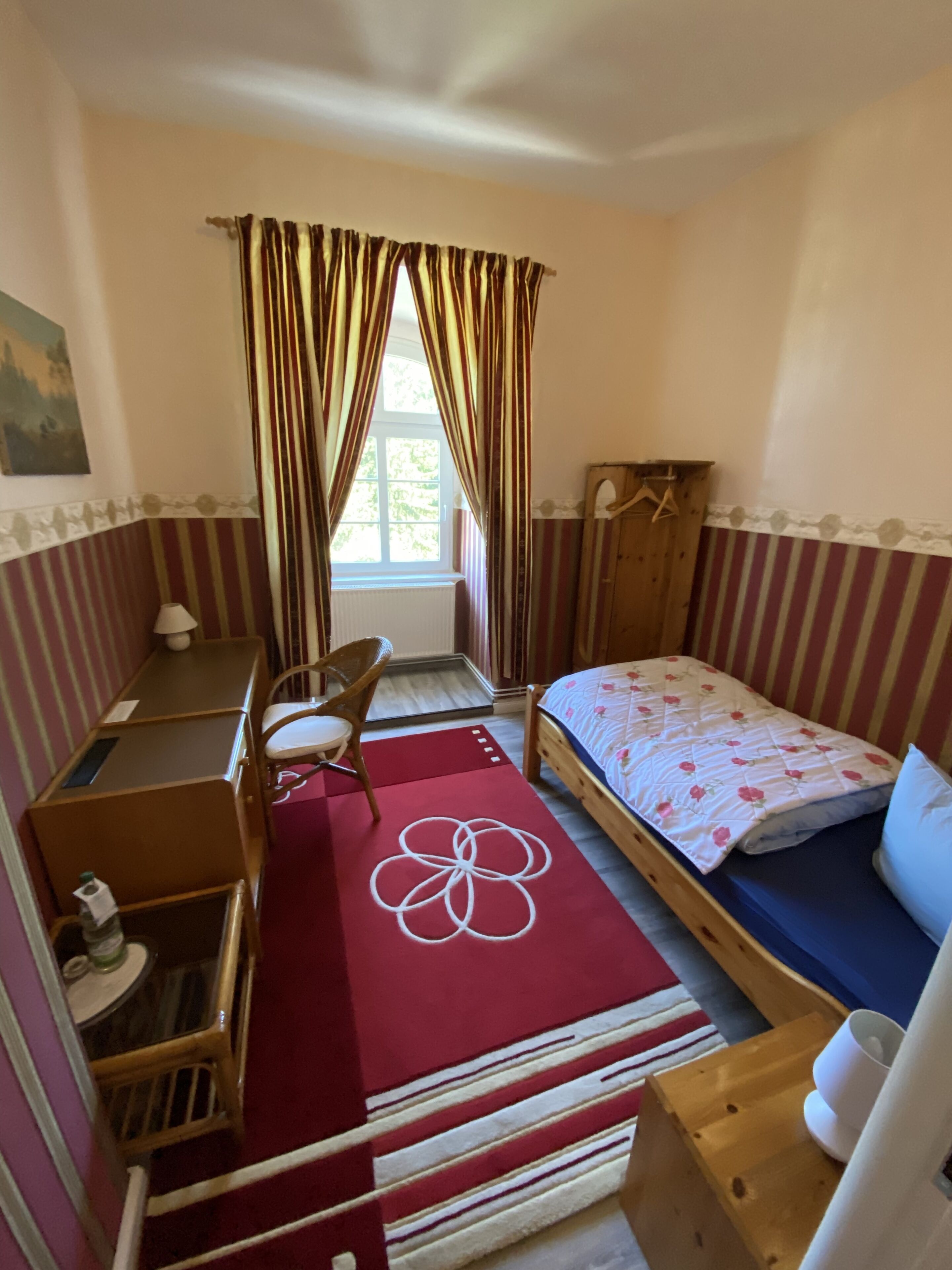 A compact room with a bed, a desk, and a chair.