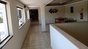 Un couloir comprenant un coin repas, un extincteur et un ventilateur de plafond.